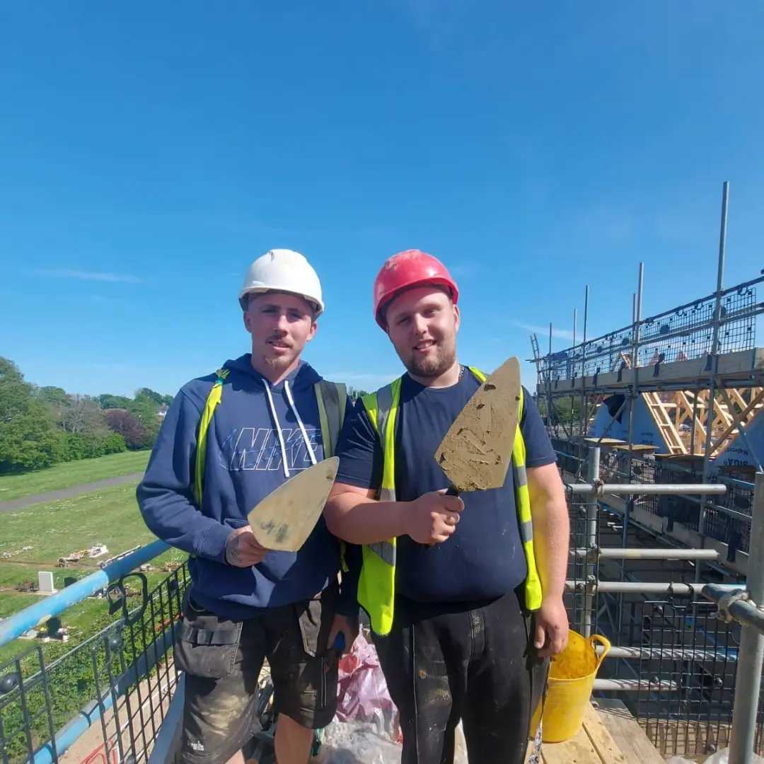 Two apprentices, Ignas is on the right, Harry on the left on a building site.